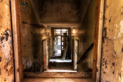 Einen Flur mit schälender Farbe und einer zerbrochenen Tür