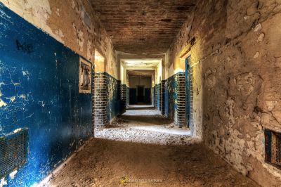 Einen langen Flur mit einer blauen Wand und einer Ziegelwand