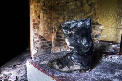 Ein Paar schmutziger Schuhe, die auf einer Ziegelwand sitzen