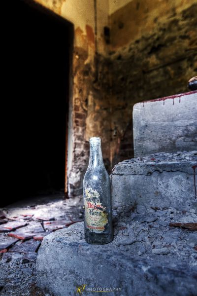 Eine Flasche Bier auf Steintreppen sitzend