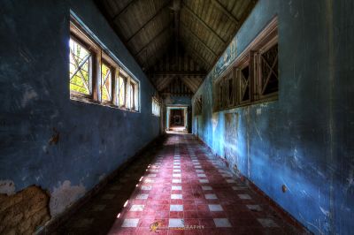 Einen langen Flur mit einem karierten Boden und einem Fenster