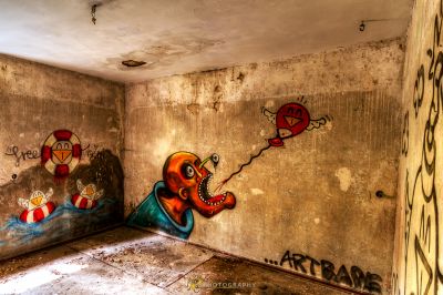 Ein Raum mit Graffiti an den Wänden und eine Wand mit einem Gemälde eines Mannes und einer Frau