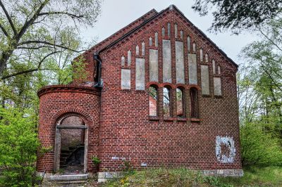 Ein Ziegelgebäude mit einem zerbrochenen Fenster und einer kaputten Tür