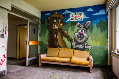 Eine Couch in einem Raum mit einem Gemälde von einem Bären und einem Kaninchen