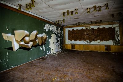 Ein Zimmer mit einer grünen Wand und einer zerbrochenen Decke