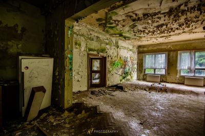 Ein Zimmer mit vielen Trümmern und einem kaputten Kühlschrank