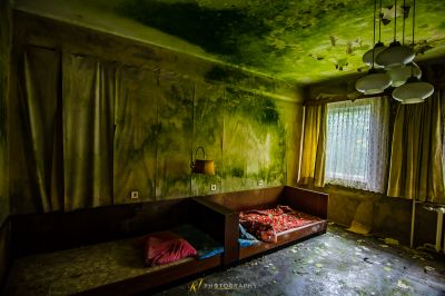 Ein Zimmer mit einem Bett und einem Deckenventilator