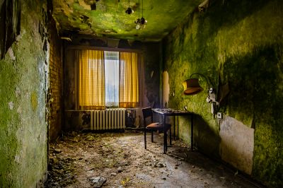 Ein Zimmer mit einem Schreibtisch und einem Fenster