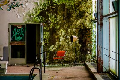 Ein Zimmer mit einem Stuhl und einer mit Graffiti bedeckten Wand