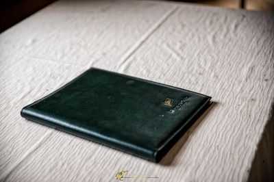 Eine kleine schwarze Brieftasche auf einem Bett