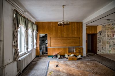 Ein Zimmer mit Holzboden und eine Wand mit Bildern