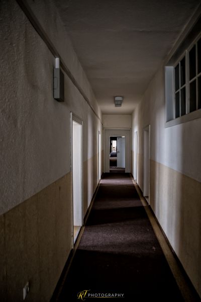 Einen langen Flur mit einer Tür und einem Fenster