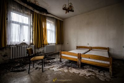 Ein Bett in einem Zimmer mit einem Fenster und einem Rad