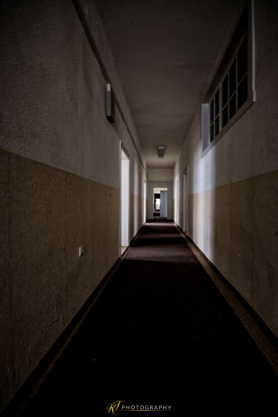 Ein langer Flur mit einem Licht, das durch die Fenster kommt