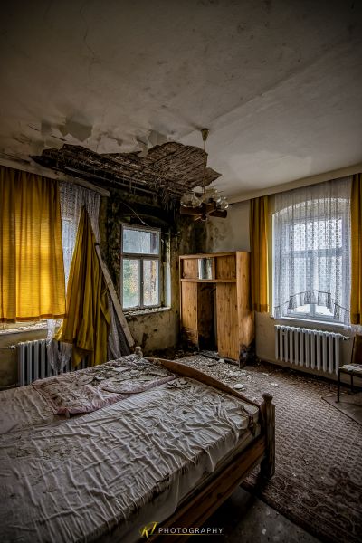 Ein Bett in einem Zimmer mit einer gebrochenen Decke
