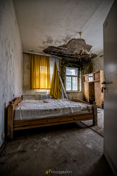 Ein Bett in einem Zimmer mit einer gebrochenen Decke