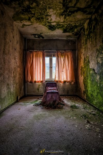 Eine Frau sitzt in einem Raum mit einem Vorhang