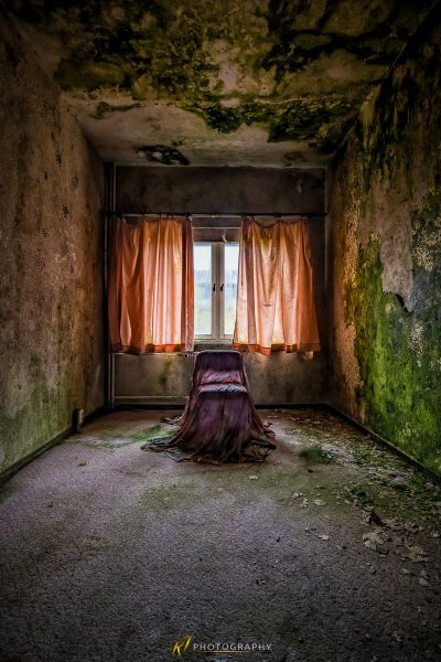 Eine Frau sitzt in einem Raum mit einem Vorhang