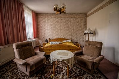 Ein Schlafzimmer mit einem Bett und zwei Stühlen