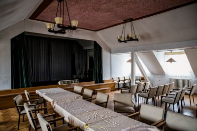 Einen langen Tisch mit Stühlen und einem Tischtuch darauf