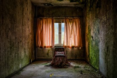 Eine Frau, die in einem Zimmer mit einem offenen Fenster sitzt