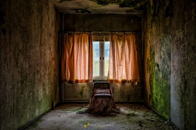 Eine Frau, die in einem Zimmer mit einem offenen Fenster sitzt