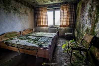 Ein Bett in einem Zimmer mit Fenster und Stuhl