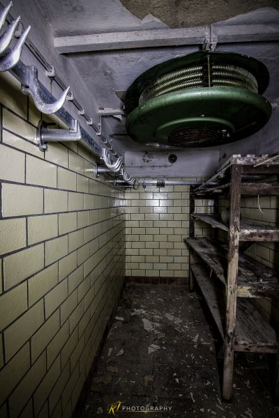 Ein schmutziges Zimmer mit einem grünen Deckenventilator