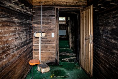 Ein Zimmer mit einer Toilette und einer hölzernen Wand