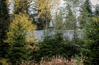 Ein Haus im Wald mit einer Uhr auf der Vorderseite