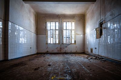 Ein Zimmer mit Fenster und Fliesenboden