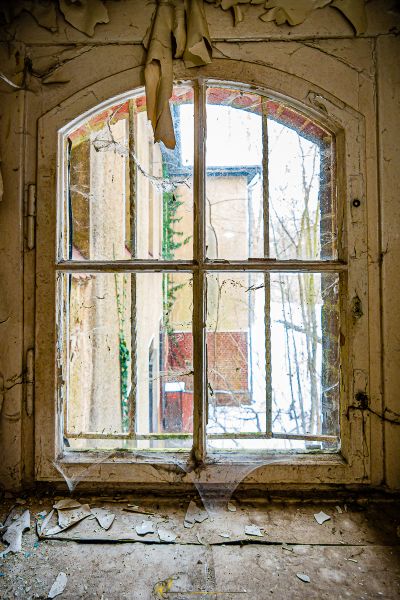 Ein Fenster mit einem zerbrochenen Glas in einem alten Gebäude