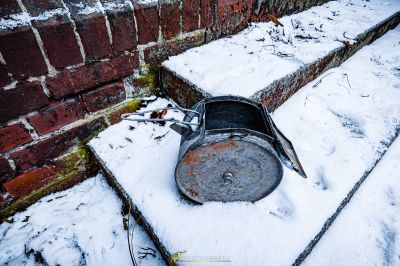 Ein Metalleimer, der im Schnee auf dem Boden sitzt