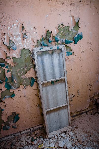 Eine zerbrochene Tür in einem Raum mit schälender Farbe