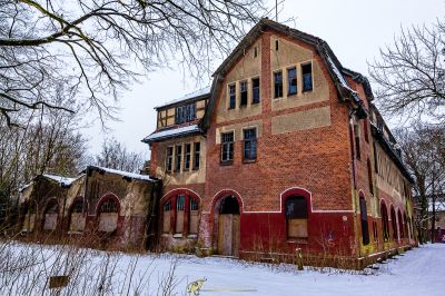 Ein rotes Backsteingebäude mit einem schneebedeckten Dach