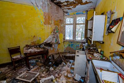 Ein Zimmer mit vielen Trümmern und einem kaputten Kühlschrank