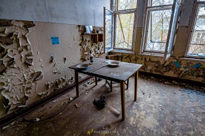 Ein kaputter Schreibtisch in einem Zimmer mit einem kaputten Fenster