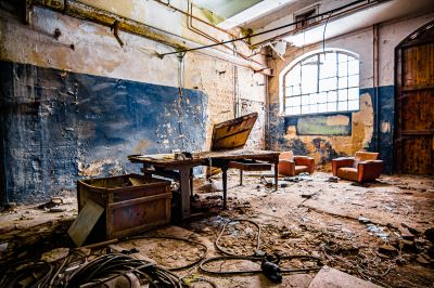 Ein Zimmer mit einem kaputten Stuhl und einem kaputten Fenster