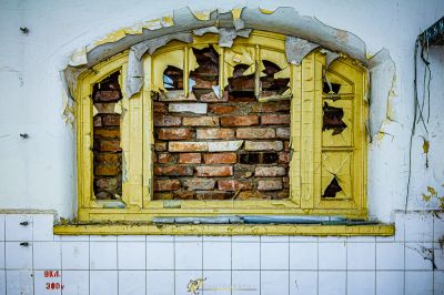 Ein zerbrochenes Fenster mit einer Ziegelwand im Hintergrund
