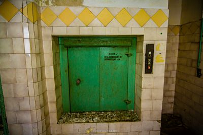 Eine grüne Tür in einem Badezimmer mit einem gelben Pfeil an der Wand