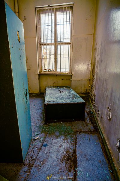 Ein schmutziges Zimmer mit einem Bett und einem Fenster