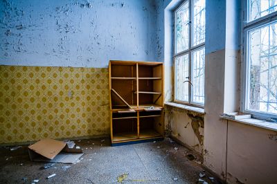 Ein Zimmer mit einem zerbrochenen Bücherregal und einem zerbrochenen Fenster