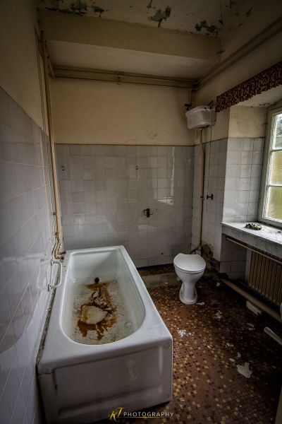 Eine Badewanne in einem Badezimmer mit einer kaputten Toilette