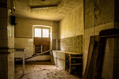 Ein schmutziges Badezimmer mit einem gebrochenen Waschbecken und einem Spiegel