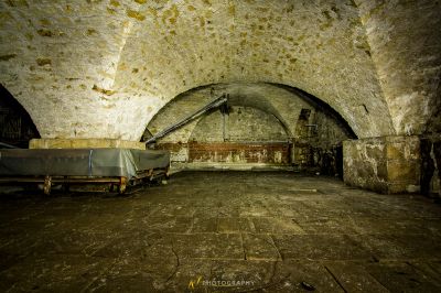 Ein Zimmer mit einer großen Steinmauer und einer Holzbank