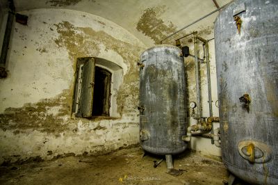 Ein schmutziges Badezimmer mit einem großen Metalltank