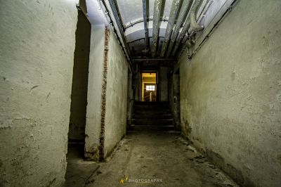 Ein langer schmaler Flur mit einem Licht, das durch die Decke kommt