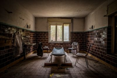 Ein Zimmer mit einem kaputten Stuhl und einem kaputten Fenster