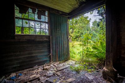Ein altes Gebäude mit einem kaputten Fenster und einer kaputten Tür