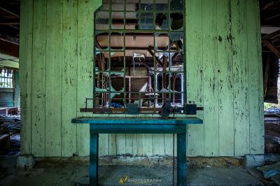 Eine grüne Bank in einem heruntergekommenen Gebäude